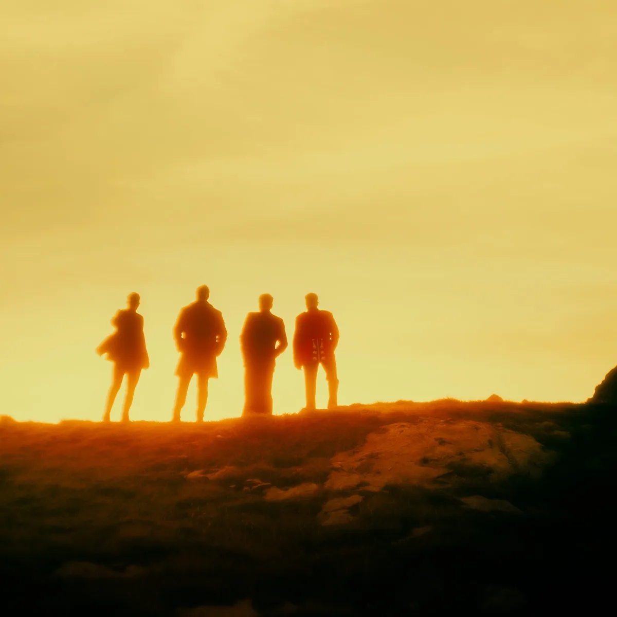A02 // Lost In Time single artwork: the four band members in silhouette against a golden sky